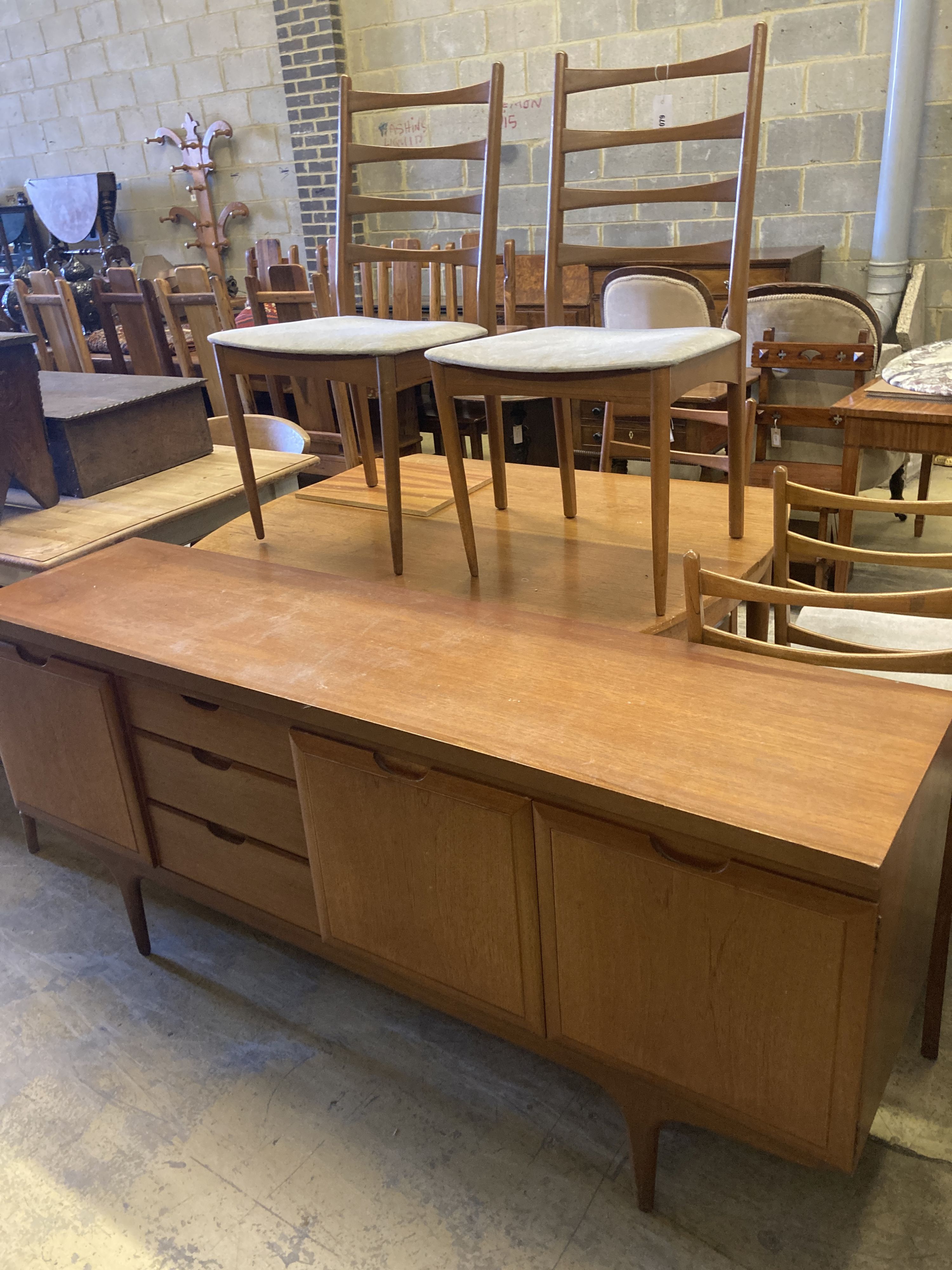 A mid 20th century Heals retailed teak dining suite comprising sideboard, extending dining table, length 127cm, width 90cm, height 74cm